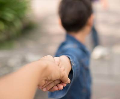  Boy looking back and pulling away from parent